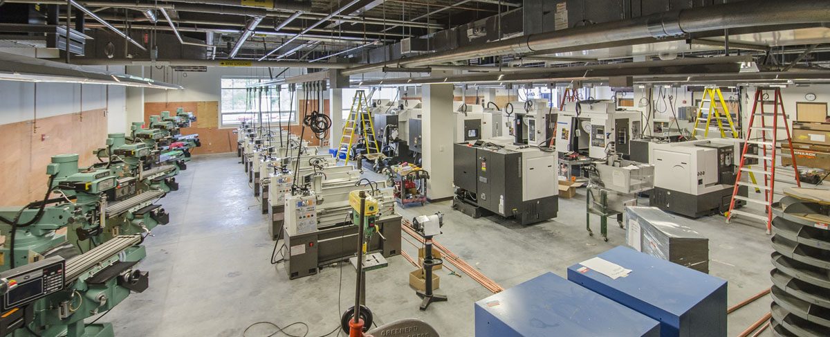 The Compumachine Technology Center shop floor at Essex Technical High School: rows of Hyundai WIA machining centres and lathes, and a line of manual mills